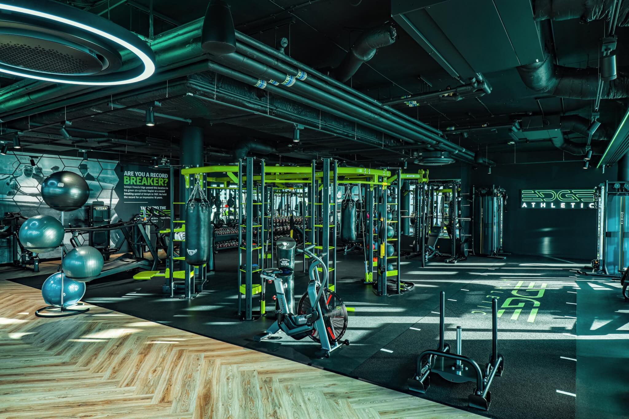 Gym floor with weights, exercise balls and 'Edge Athletic' signage