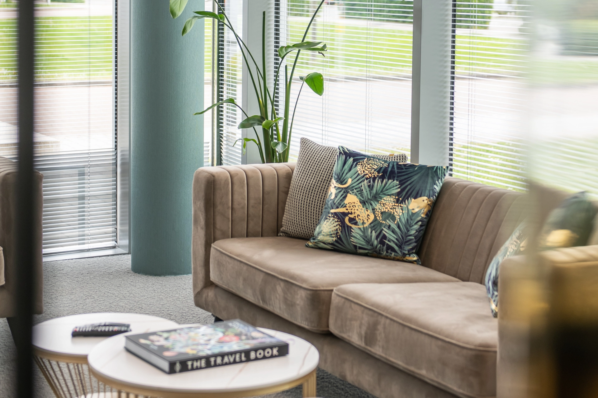 Stylish lounge seating with patterned cushions beside a window and a coffee table