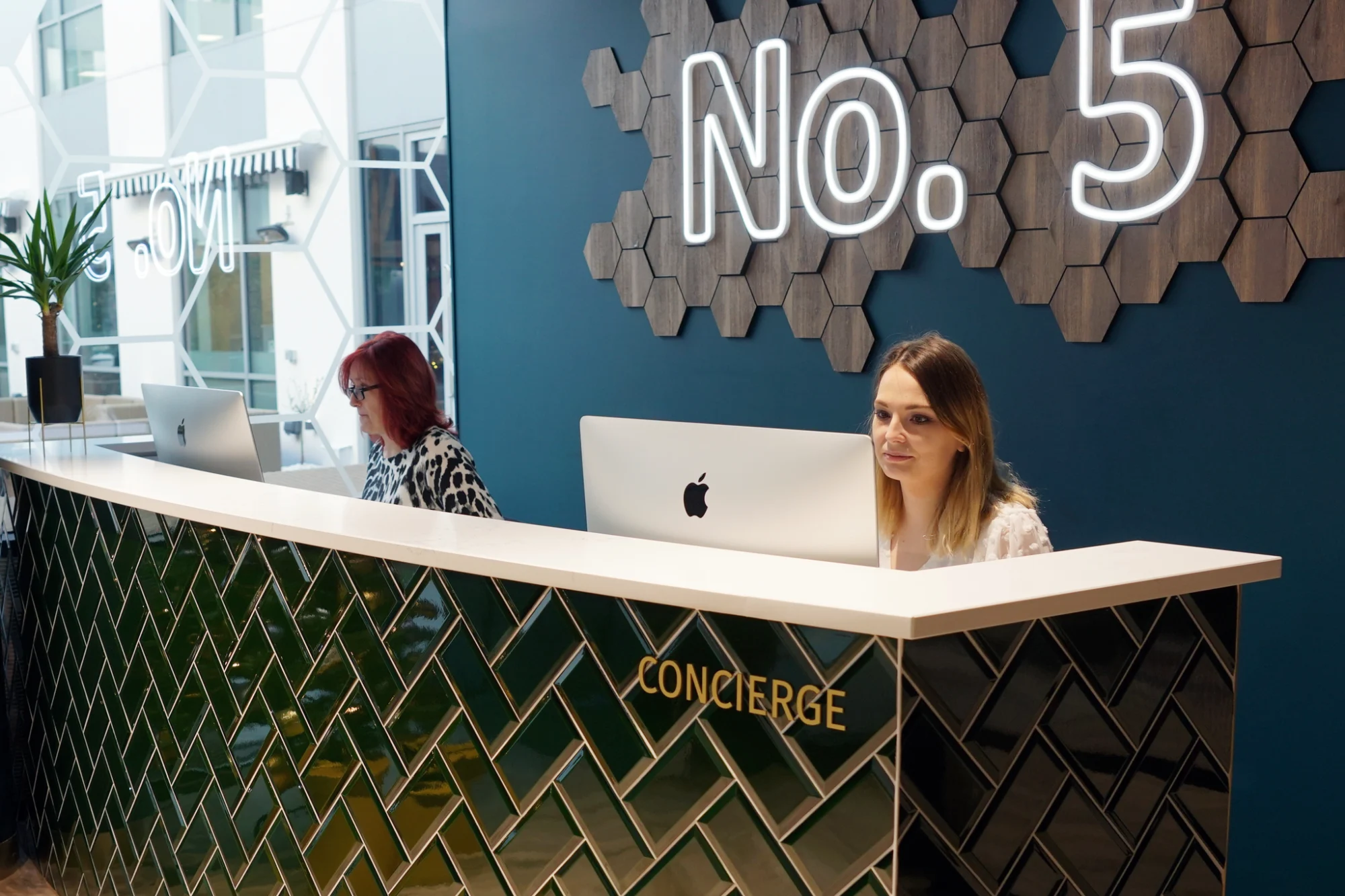 No.5 reception desk with concierge staff and an illuminated 'No. 5' sign